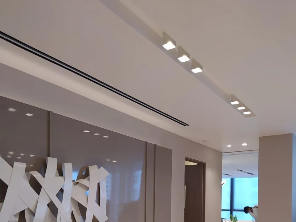 Hall con cielo raso de gypsum, spots empotrados y difusor lineal a lo largo del mueble