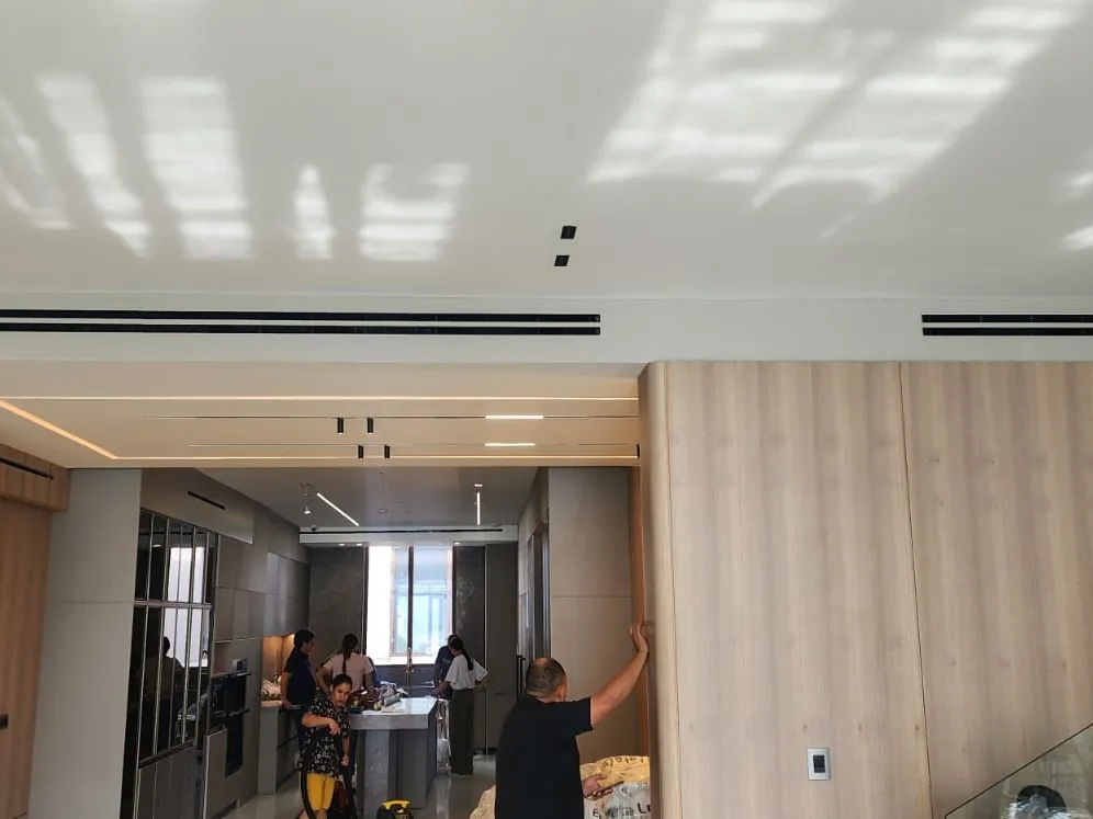 Kitchen and living room with linear ducted air conditioning diffusers in the ceiling